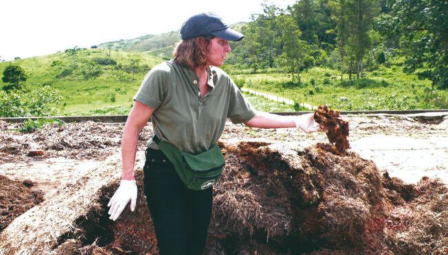 Mulher realizando compostagem de carcaças de animais.